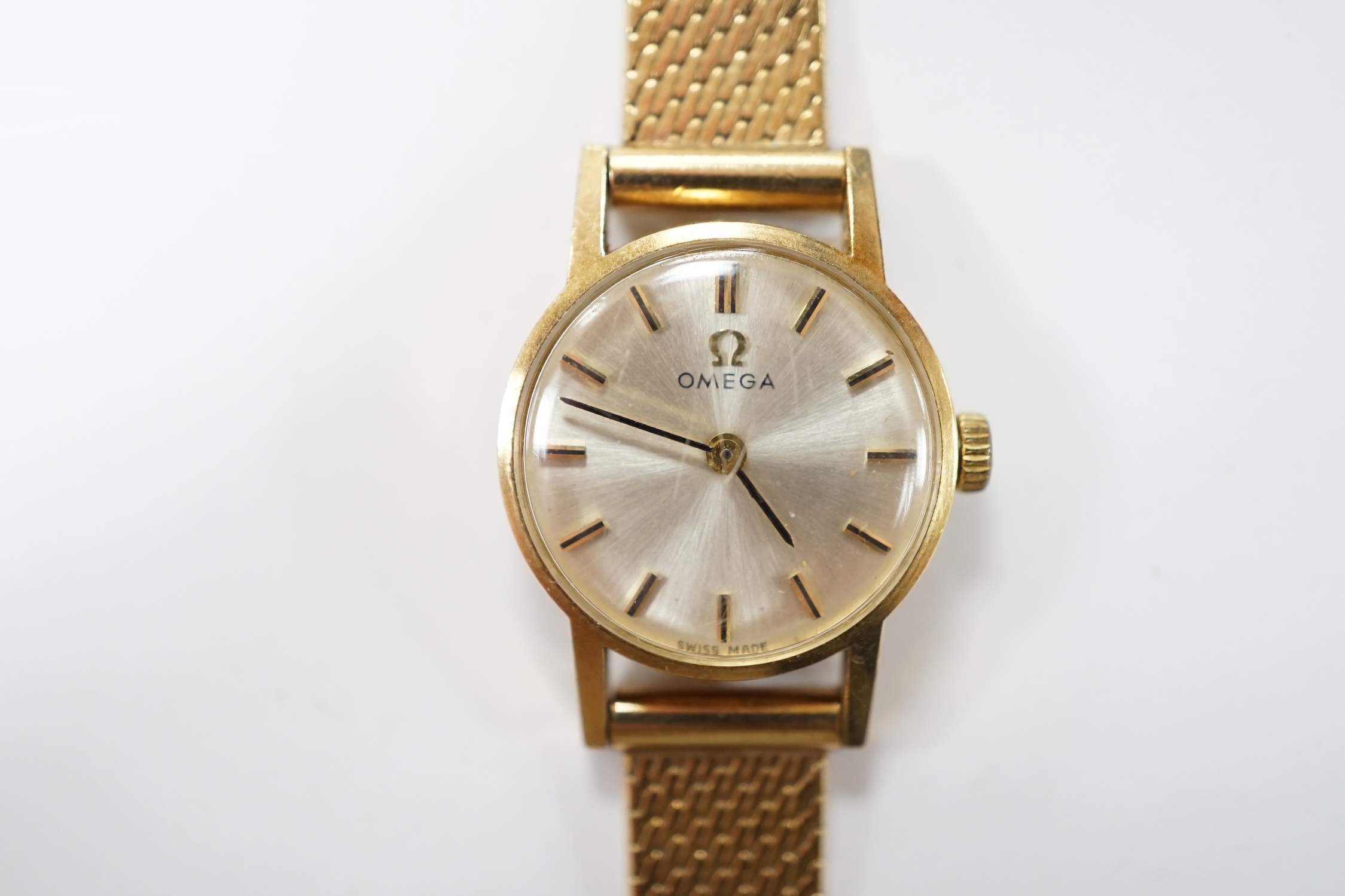 A lady's modern 9ct gold Omega manual wind wrist watch, on an associated 9ct gold bracelet, overall 18cm, gross weight 21.8 grams. Condition - fair